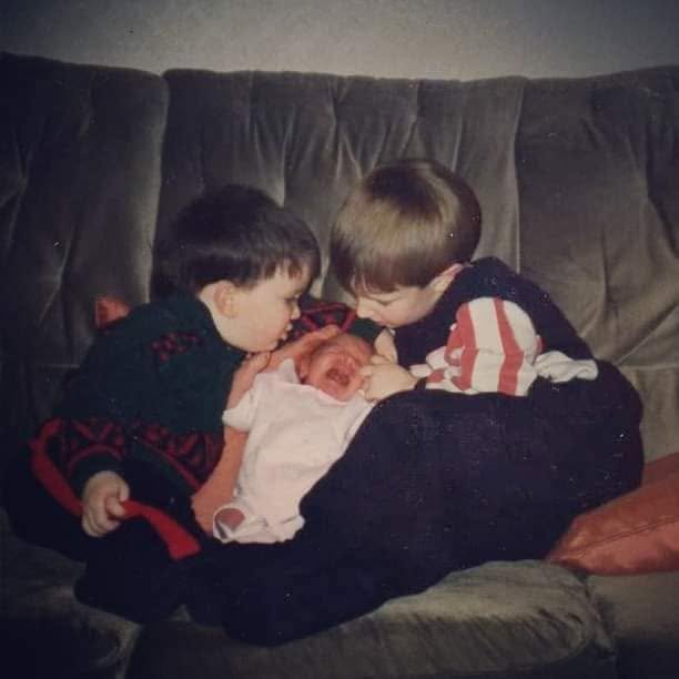 The Rabbit and its older brother leaning over their newborn sister